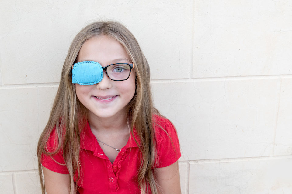 Child in glasses with Occluder. Ortopad Girls Eye Patches nozzle for glasses for treating strabismus (lazy eye)